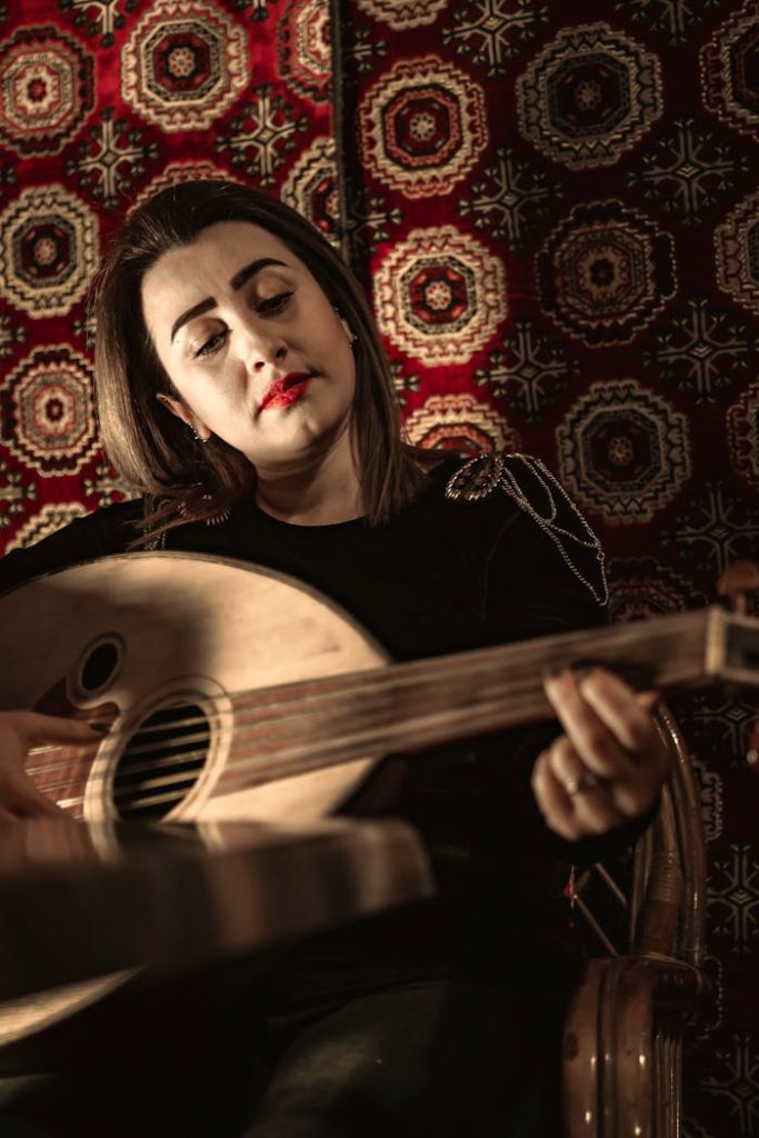 A woman plays an oud against a backdrop of traditional patterned rugs in Gaziantep, Turkey.
